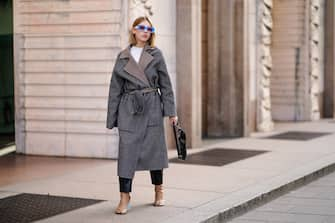 MILAN, ITALY - FEBRUARY 20: Dagmara Jarzynka wears blule sunglasses, a gray oversized long coat with checked inner lining, a white top, a black shiny bag, pale brown leather boots, outside Vivetta, during Milan Fashion Week Fall/Winter 2020-2021 on February 20, 2020 in Milan, Italy. (Photo by Edward Berthelot/Getty Images)