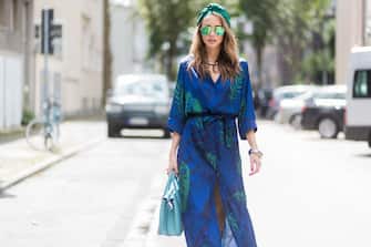 DUESSELDORF, GERMANY - AUGUST 4: Model and fashion blogger Alexandra Lapp wearing a blue Kimono maxi dress with green leaf print from Borgo de Nor, green metallic Aviator sunglasses by Ray-Ban, plateau heels from Prada, Milla MCM bag in turquoise, a green bandana turban, neck ripe and bracelet in grey gold by Schubart Goldschmiede, three rings in grey gold with a green Tourmaline by Schubart on August 4, 2017 in Duesseldorf, Germany. (Photo by Christian Vierig/Getty Images)