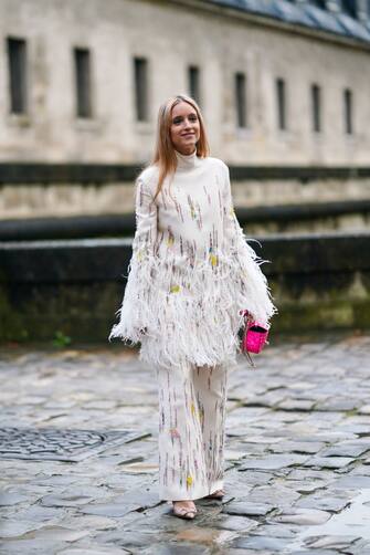 PARIS, FRANCE - MARCH 01: Charlotte Groeneveld wears a white turtleneck pullover with fringes, flared pants, a pink bag, pointy shoes, outside Valentino, during Paris Fashion Week - Womenswear Fall/Winter 2020/2021, on March 01, 2020 in Paris, France. (Photo by Edward Berthelot/Getty Images)