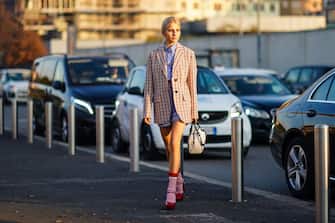 MILAN, ITALY - JANUARY 12: Caroline Daur wears a checked oversized blazer jacket, a Prada white and black bag, pink wool socks, red shoes, a blue striped shirt, outside Prada, during Milan Fashion Week Menswear Fall/Winter 2020/2021, on January 12, 2020 in Milan, Italy. (Photo by Edward Berthelot/Getty Images)