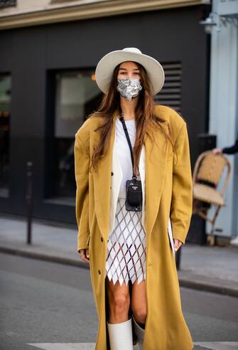 PARIS, FRANCE - OCTOBER 04: Estelle Chemouny seen wearing hat, beige coat, skirt, white boots, blazer, micro Prada bag outside Paco Rabanne during Paris Fashion Week - Womenswear Spring Summer 2021 : Day Seven on October 04, 2020 in Paris, France. (Photo by Christian Vierig/Getty Images)