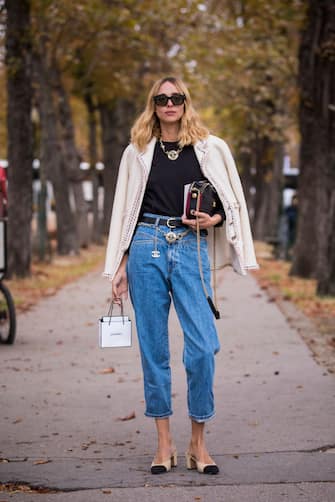 PARIS, FRANCE - OCTOBER 02: Candela Pelizza, wearing a black top, blue jeans with Chanel belt, Chanel shoes, black Chanel bag and nude jacket, is seen after the Chanel show on October 2, 2018 in Paris, France. (Photo by Claudio Lavenia/Getty Images)
