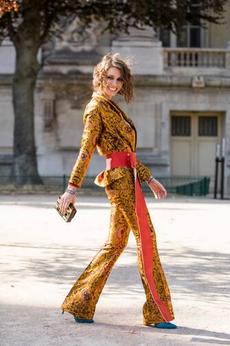 PARIS, FRANCE - SEPTEMBER 29:  Landiana Cerciu, wearing a printed top, printed suit with a large orange belt and blue shoes, is seen before the Elie Saab show on September 29, 2018 in Paris, France. (Photo by Claudio Lavenia/Getty Images)