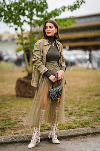 PARIS, FRANCE - SEPTEMBER 24: Camila Coelho wears a khaki green jacket, a golden necklace, green turtleneck wool pullover, a Dior monogram Saddle bag, white mesh boots, outside Dior, during Paris Fashion Week - Womenswear Spring Summer 2020, on September 24, 2019 in Paris, France. (Photo by Edward Berthelot/Getty Images)
