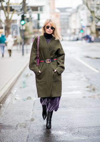 DUESSELDORF, GERMANY - DECEMBER 10: Gitta Banko wearing a lilac velvet dress and an green oversized knitted cardigan by Dawid Tomaszewski, logo belt from Gucci, black tubular nappa leather ankle boots by Yeezy, purple colored Timeless Chanel bag with golden hardware and Ray Ban round metal sunglasses, rose gold Y ring with purple amethyst by York Watches on December 10, 2017 in Duesseldorf, Germany. (Photo by Christian Vierig/Getty Images)