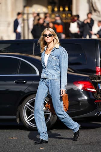 PARIS, FRANCE - SEPTEMBER 30: Camille CharriÃ¨re wears earrings, sunglasses, a white top, a washed-out light blue denim jacket with a cream-color fluffy collar, washed out light blue denim full-length pants, black boots, a brown large bag, outside Stella McCartney, during Paris Fashion Week - Womenswear Spring Summer 2020, on September 30, 2019 in Paris, France.  (Photo by Edward Berthelot / Getty Images)