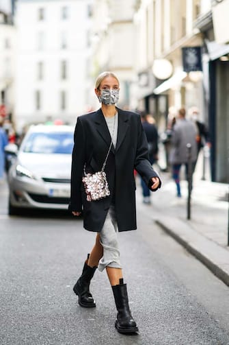 PARIS, FRANCE - OCTOBER 04: Leonie Hanne wears a black oversized blazer jacket, a grey glitter dress, a silver shiny sequined bag with attached floral designs, black leather boots, a silver shiny protective face mask, outside Paco Rabanne, during Paris Fashion Week - Womenswear Spring Summer 2021, on October 04, 2020 in Paris, France. (Photo by Edward Berthelot/Getty Images)