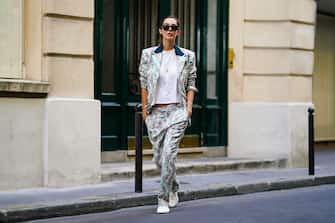 PARIS, FRANCE - AUGUST 26: Estelle Chemouny wears pastel green / pink floral print suit from Charles Jeffrey for Paradise Garage Store, a golden necklace, a white t-shirt, white flat shoes with golden logo from Malibu Hotel, Ray-Ban sunglasses, on August 26, 2020 in Paris, France. (Photo by Edward Berthelot/Getty Images)