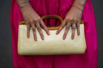 PARIS, FRANCE - AUGUST 02: Gabriella Berdugo wears a Fuchsia neon pink dress, finger rings, a vintage vinyl beige long bag with embossed monograms from Louis Vuitton, on August 02, 2021 in Paris, France. (Photo by Edward Berthelot/Getty Images)