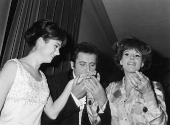 Italian singer-songwriter and actor Domenico Modugno kissing Gigliola Cinquetti and Ornella Vanoni's hands at 16th Sanremo Music Festival. Sanremo, January 1966  (Photo by Mondadori via Getty Images)