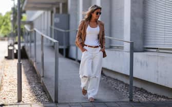 DUSSELDORF, GERMANY - JUNE 12: Gitta Banko seen wearing a Ray Ban sunglasses, a brown linen blazer from Darling Harbor, a white destroyed off-white denim pants from Closed, a tank top from Zara, rhinestone sandals from Aminah Abdul Jillil, a brown leather belt from Celine and a brown leather Bottega Veneta Teen Jodie bag on June 12, 2022 in Dusseldorf, Germany.  (Photo by Jeremy Moeller / Getty Images)