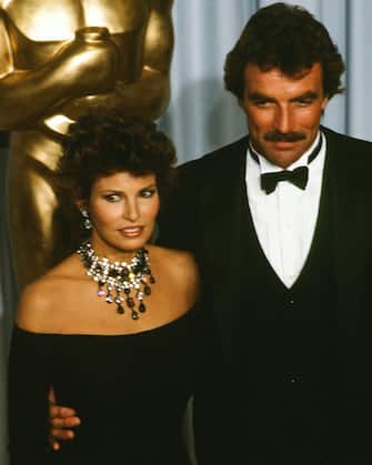 LOS ANGELES,CA - APRIL 11, 1983: Actress Raquel Welch poses with actor Tom Selleck backstage during the 55th Academy Awards at Dorothy Chandler Pavilion, Los Angeles, California. (Photo by Michael Montfort/Michael Ochs Archives/Getty Images) 