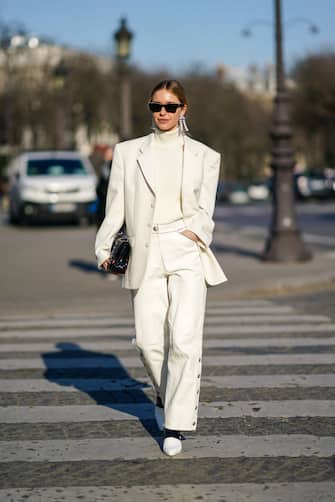 PARIS, FRANCE - JANUARY 21: Pernille Teisbaek wears sunglasses, earrings, a white turtleneck pullover, an oversized blazer jacket, a Chanel quilted bag, flare pants, pointy shoes, outside Chanel, during Paris Fashion Week - Haute Couture Spring/Summer 2020, on January 21, 2020 in Paris, France. (Photo by Edward Berthelot/Getty Images )