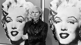 22/02/1987: Died on this day American Pop artist and film maker Andy Warhol  America's pop-art painter and film-maker, Andy Warhol, stands in front of his double portrait of the late Hollywood film star, Marilyn Monroe, at the Tate Gallery, Millbank, at a press preview of his exhibition.   (Photo by PA Images via Getty Images)