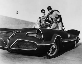 Adam West and Burt Ward as Batman and Robin atop the Batmobile, in the famously campy TV series Batman, early in the show's run in 1966.