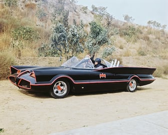 American actor Adam West as Bruce Wayne/Batman at the wheel of the Batmobile with passenger Burt Ward as Dick Grayson/Robin in the TV series 'Batman', circa 1966. The Batmobile was a modified version of the 1955 Lincoln Futura concept car. (Photo by Silver Screen Collection/Hulton Archive/Getty Images) 