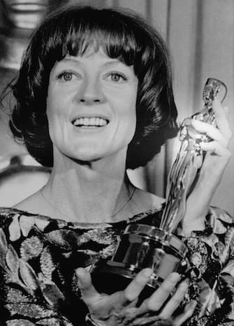 (Original Caption) 04/09/1979-Hollywood, CA: Actress Maggie Smith is all smiles as she holds up her "Oscar" which she won as Best Actress in a Supporting Role at the 51st Annual Academy Awards at the Music Center. She won it for her role in the comedy "California Suite".