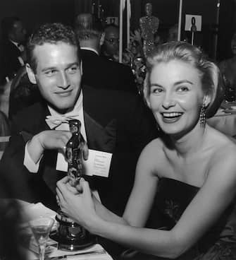 1958:  American actor Joanne Woodward holds her Oscar statuette while sitting next to husband, American actor Paul Newman, during the Governor's Ball, an Academy Awards party held at The Beverly Hilton Hotel, Beverly Hills, California. Woodward won the Best Actress Oscar for director Nunnally Johnson's, 'The Three Faces of Eve.'  (Photo by Darlene Hammond/Hulton Archive/Getty Images)