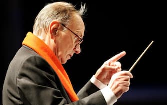 Milan, ITALY:  Italian composer Ennio Morricone conducts the Christmas concert in Milan's Piazza Duomo 16 December 2006. Morricone, the man behind the memorable music used in Sergio Leone's spaghetti westerns, will be presented with an honorary Oscar at the 2007 Oscars in Hollywood, 25 February 2007.   AFP PHOTO / Filippo MONTEFORTE  (Photo credit should read FILIPPO MONTEFORTE/AFP via Getty Images)