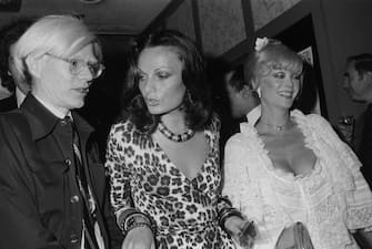 14th May 1974:  Left to right: Artist Andy Warhol (1928 - 1987), fashion designer Diane von Furstenberg, and actor Monique Van Vooren, star of Warhol's 'Flesh for Frankenstein,' at the film's premiere at the Trans-Lux East Theater in New York City. Von Furstenberg is wearing one of her own designs, a leopard print wrap-dress.  (Photo by Tim Boxer/Hulton Archive/Getty Images)