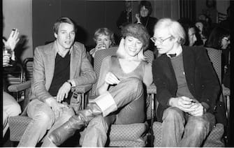 American Pop artist Andy Warhol (1928 - 1987) (right) speaks to French singer and actress Andrea Lear at the premiere of 'Shampoo' (directed by Hal Ashby) at the Columbia Pictures Screening Room, New York, New York, February 1975. (Photo by Tim Boxer/Getty Images)