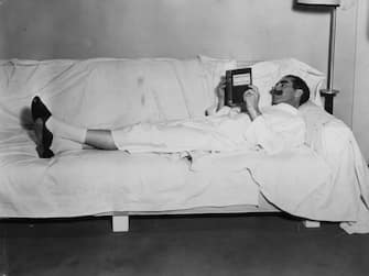 1933:  American comic Groucho Marx (1888-1964) reading 'Principals of Education' during a break in the filming of 'Duck Soup'.  (Photo by Hulton Archive/Getty Images)