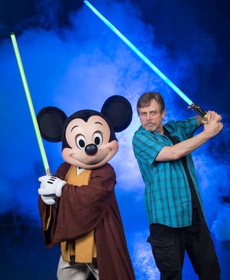 LAKE BUENA VISTA, FL - JUNE 05:  In this handout photo provided by Disney Parks, actor Mark Hamill, who portrayed Luke Skywalker in the 'Star Wars' film saga, poses with Jedi Mickey Mouse at Disney's Hollywood Studios June 5, 2014 in Lake Buena Vista, Florida.  Hamill is at the Walt Disney World Resort theme park for appearances June 6-8 at "Star Wars Weekends," an annual special event.  This year marks the first time Hamill has attended 'Star Wars Weekends' in the event's 17-year history.  (Photo by David Roark/Disney Parks via Getty Images)