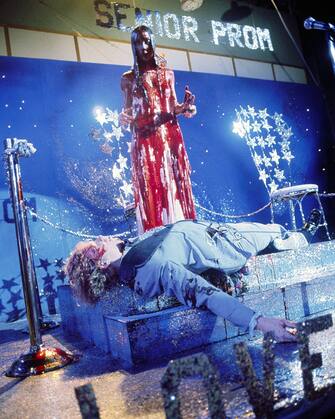 153462077 Drenched in pig's blood, Carrie White, played by Sissy Spacek, stares in shock at her ill-fated prom date, Tommy, played by William Katt, in Brian De Palma's horror film 'Carrie', 1976. (Photo by Silver Screen Collection / Getty Images)