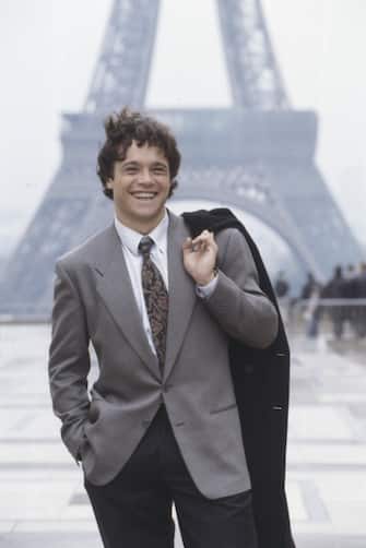 Italian actor Claudio Amendola smiling in front of the Eiffel Tower. Paris, 1990. (Photo by Rino Petrosino/Mondadori via Getty Images)
