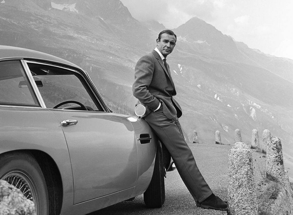 1964:  Actor Sean Connery poses as James Bond next to his Aston Martin DB5 in a scene from the United Artists release 'Goldfinger' in 1964.  (Photo by Michael Ochs Archives/Getty Images)