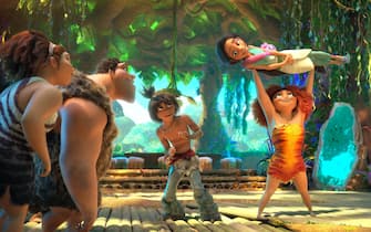(from left) Ugga Crood (Catherine Keener), Grug Crood (Nicolas Cage), Guy (Ryan Reynolds), Eep Crood (Emma Stone) holding Dawn Betterman (Kelly Marie Tran), Hope Betterman (Leslie Mann) and Phil Betterman (Peter Dinklage) in DreamWorks Animation's The Croods: A New Age, directed by Joel Crawford.
