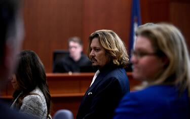 US actor Johnny Depp (C) is seen during the $50 million Depp vs Heard defamation trial at the Fairfax County Circuit Court in Fairfax, Virginia, on April 12, 2022. - Allegations of domestic abuse levelled against Depp by US actress Amber Heard have had a "devastating" impact on his career, his lawyers said Tuesday at the opening of the actor's defamation case against his former wife. (Photo by BRENDAN SMIALOWSKI / POOL / AFP) (Photo by BRENDAN SMIALOWSKI/POOL/AFP via Getty Images)