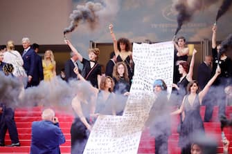 CANNES, FRANCE - MAY 22: Members of the feminist movement "Les Colleuses" hold a banner, displaying the names of 129 women who died as a result of domestic violence ahead of the screening of "Holy Spider" during the 75th annual Cannes film festival at Palais des Festivals on May 22, 2022 in Cannes, France. (Photo by Andreas Rentz/Getty Images)