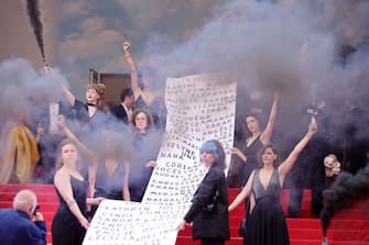 CANNES, FRANCE - MAY 22: Members of the feminist movement "Les Colleuses" hold a banner, displaying the names of 129 women who died as a result of domestic violence ahead of the screening of "Holy Spider" during the 75th annual Cannes film festival at Palais des Festivals on May 22, 2022 in Cannes, France. (Photo by Andreas Rentz/Getty Images)