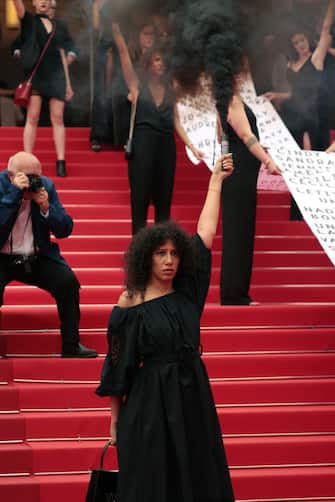 CANNES, FRANCE - MAY 22: Members of the feminist movement "Les Colleuses" hold a banner, displaying the names of 129 women who died as a result of domestic violence ahead of the screening of "Holy Spider" during the 75th annual Cannes film festival at Palais des Festivals on May 22, 2022 in Cannes, France. (Photo by John Phillips/Getty Images)