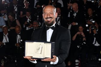 CANNES, FRANCE - MAY 28: Director Tarik Saleh poses with the Best Screenplay Award for the movie 'Walad Min Al Janna' (Boy From Heaven) during the winner photocall during the 75th annual Cannes film festival at Palais des Festivals on May 28, 2022 in Cannes, France. (Photo by Pascal Le Segretain/Getty Images)