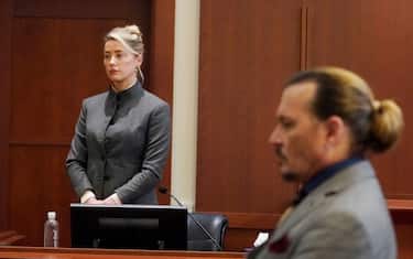 TOPSHOT - US actors Amber Heard (L) and Johnny Depp watch as the jury leaves the courtroom at the end of the day at the Fairfax County Circuit Courthouse in Fairfax, Virginia, May 16, 2022. - US actor Johnny Depp sued his ex-wife Amber Heard for libel in Fairfax County Circuit Court after she wrote an op-ed piece in The Washington Post in 2018 referring to herself as a "public figure representing domestic abuse." (Photo by Steve Helber / POOL / AFP) (Photo by STEVE HELBER/POOL/AFP via Getty Images)
