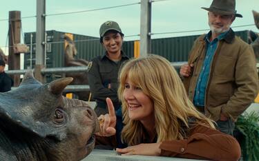 (from left) A baby Nasutoceratops, Dr. Ellie Sattler (Laura Dern) and Dr. Alan Grant (Sam Neill) in Jurassic World Dominion, co-written and directed by Colin Trevorrow.