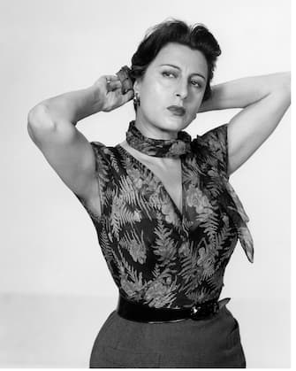 1281365977 Italian Actress Anna Magnani (1908-1973) as â Serafina Delle Roseâ in a floral outfit and attaching a flower to her head in the role that gave her an Oscar victory for best actress, posing in a publicity shot from the movie â The Rose Tattooâ , 1955, United States. (Photo by Paramount Pictures/De Carvalho Collection/Getty Images)