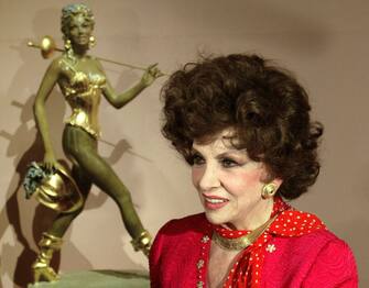 Italian actress Gina Lollobrigida poses for a picture in front of her sculpture before opening of her sculpture exhibition at Pushkin Fine Arts museum in Moscow on 23 June, 2003. AFP PHOTO/MAXIM MARMUR (Photo by MAXIM MARMUR / AFP) (Photo by MAXIM MARMUR/AFP via Getty Images)