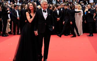 US actor Harrison Ford (R) arrives with his wife US actress Calista Flockhart for the screening of the film "Indiana Jones and the Dial of Destiny" during the 76th edition of the Cannes Film Festival in Cannes, southern France, on May 18, 2023. (Photo by Valery HACHE / AFP) (Photo by VALERY HACHE/AFP via Getty Images)