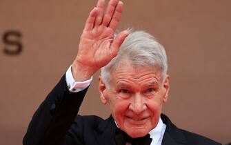 US actor Harrison Ford waves as he arrives for the screening of the film "Indiana Jones and the Dial of Destiny" during the 76th edition of the Cannes Film Festival in Cannes, southern France, on May 18, 2023. (Photo by Valery HACHE / AFP) (Photo by VALERY HACHE/AFP via Getty Images)