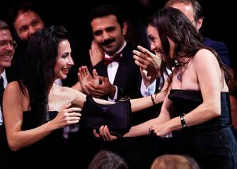 Turkish actress Merve Dizdar (R) reacts after she won the Best Actress Prize for her part in the film "Kuru Otlar Ustune" (About Dry Grasses) during the closing ceremony of the 76th edition of the Cannes Film Festival in Cannes, southern France, on May 27, 2023. (Photo by Valery HACHE / AFP) (Photo by VALERY HACHE/AFP via Getty Images)