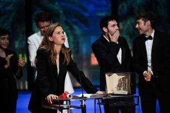 French director Justine Triet reacts on stage after she won the Palme d'Or for the film "Anatomie d'une Chute" (Anatomy of a Fall) during the closing ceremony of the 76th edition of the Cannes Film Festival in Cannes, southern France, on May 27, 2023. (Photo by CHRISTOPHE SIMON / AFP) (Photo by CHRISTOPHE SIMON/AFP via Getty Images)