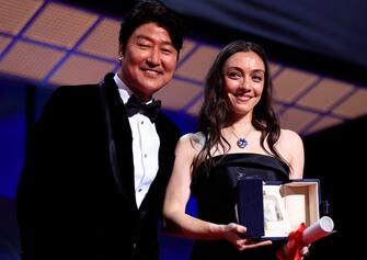 Turkish actress Merve Dizdar (R) poses on stage with South Korean actor Song Kang-ho (L) after she won the Best Actress Prize for her part in the film "Kuru Otlar Ustune" (About Dry Grasses) during the closing ceremony of the 76th edition of the Cannes Film Festival in Cannes, southern France, on May 27, 2023. (Photo by Valery HACHE / AFP) (Photo by VALERY HACHE/AFP via Getty Images)