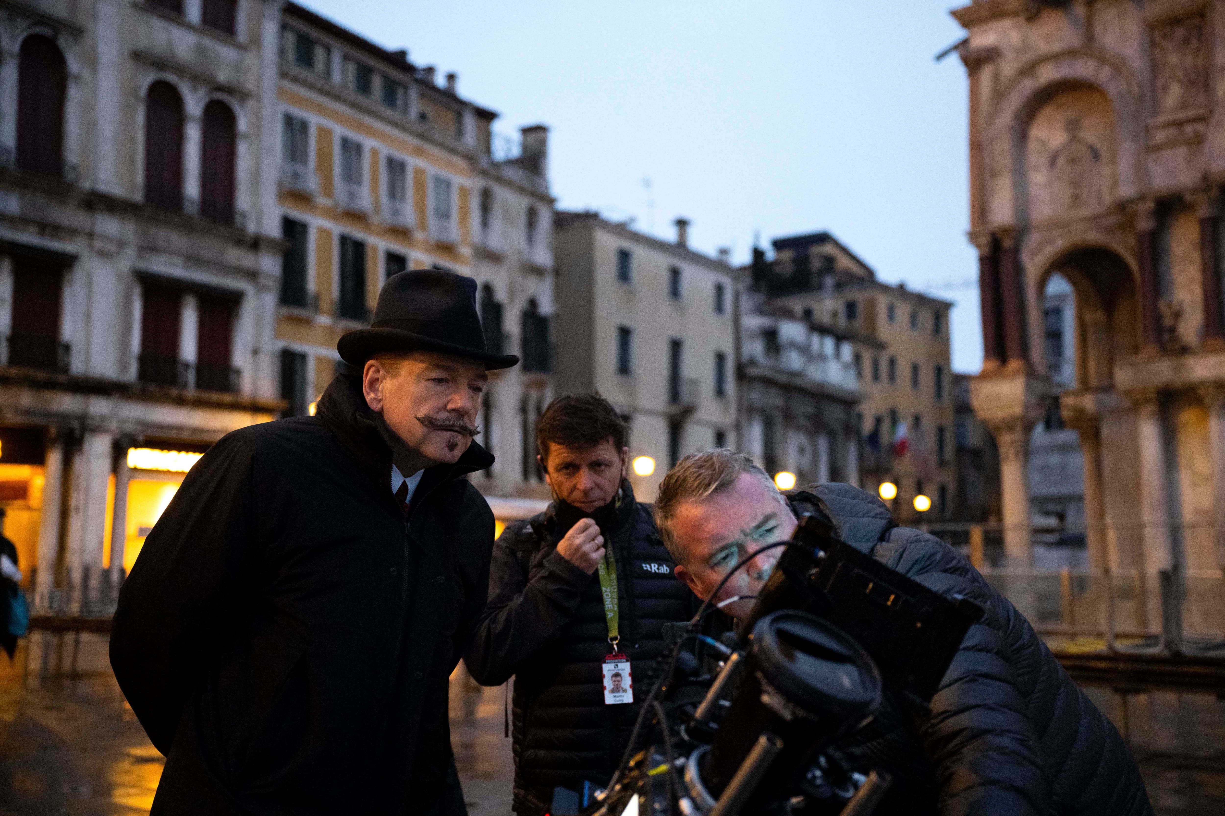 (L-R): Director Kenneth Branagh as Hercule Poirot and crew on the set of 20th Century Studios' A HAUNTING IN VENICE. Photo by Rob Youngson. © 2023 20th Century Studios. All Rights Reserved.
