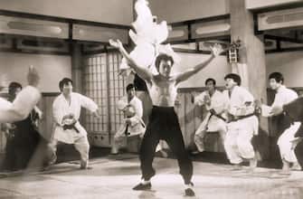(Original Caption) Picture shows actor, Bruce Lee, demonstrating a Kung-fu flip in the air of a Japanese boxing club member from a scene in "The Chinese Connection". filed 5/27/73