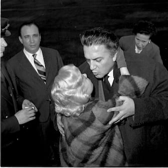 Italian film director Federico Fellini hugs and kisses his wife and actress Giulietta Masina before she leaves for Germany, Rome 1959. They are at Ciampino Airport. (Photo by Archivio Cicconi/Getty Images)