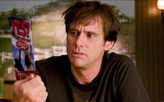 Carl (JIM CARREY) looks at the brochure from the Yes seminar in Warner Bros. Pictures' and Village Roadshow's comedy "Yes Man," distributed by Warner Bros. Pictures.