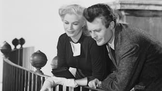 1960:  Marcello Mastroianni (1924 - 1996) and Anita Ekberg share a blissful screen moment in 'La Dolce Vita', directed by Federico Fellini.  (Photo via John Kobal Foundation/Getty Images)